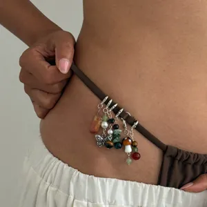 Chaine de taille tendance avec pendentifs papillon champignon cristaux style bohème chic