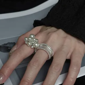 Detailed view of faux pearl and multi-layer silver open ring, elegant chic style accessory.