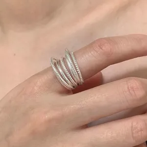 Silver multi-layer twisted rope ring close-up detail, elegant fashion finger jewelry.