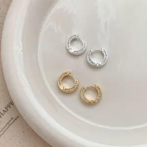 Minimalist small hoop earrings for women, featuring gold and silver paved zirconia designs.