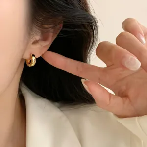 Minimalist gold hoop earrings for women, chic small circle design everyday jewelry trend.