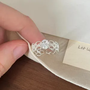 Zarter filigraner Silberring im Detail mit kunstvollem Muster und ovalem Schmuckstein.