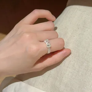 Nahaufnahme eines süßen hohlen Schleifenrings am Finger, der feine Details wunderschön zeigt.