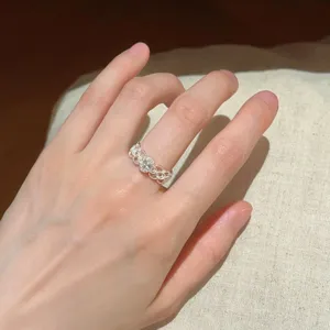 Detailaufnahme des eleganten filigranen Silberrings mit funkelndem Zirkonstein am Finger.