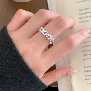 Silver floral band ring with blue stones, chic daisy design fashion jewelry for women stacking.