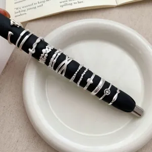 Detailed close-up shot of multiple stylish stackable silver rings displayed on black holder.