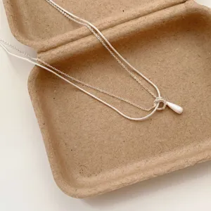 Silver double layer necklace variant, stylish metallic chain with delicate pendant accessory.
