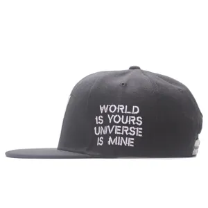 Close-up detail of black snapback hat featuring stylish side white embroidery text.