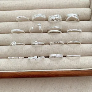 Set of sixteen elegant silver-colored stackable rings with various unique designs.