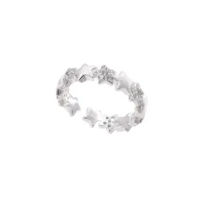 Close-up of adjustable silver star ring featuring sparkling pave stones and matte textured details.