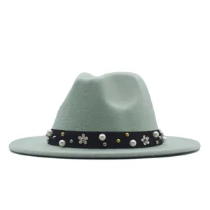 Detailansicht eines mintgrünen Fedora-Hutes mit schwarzem Band, Perlen und Blütendekor.