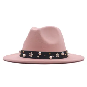 Rosa Fedora Hut Detailansicht mit schwarzem Band, verziert mit Perlen und weißen Blumen.