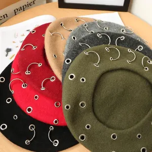 Detailed view of punk style wool beret hats with metal ring hardware in multiple autumn colors.