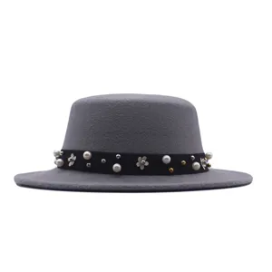 Close-up detail of the grey felt hat featuring a black band with pearl and metal floral studs.