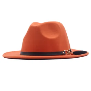 Detailansicht des orangefarbenen Wollhutes mit breiter flacher Krempe und schwarzer Quaste.
