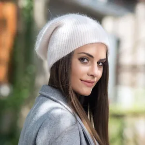 Gros plan d'un bonnet en tricot blanc doux et duveteux porté en extérieur, style d'hiver.