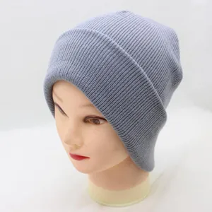 Grey ribbed knit beanie hat detail view, showing soft warm winter wool texture close up.