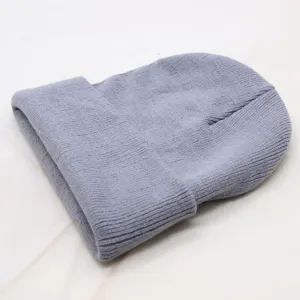 Close-up of a soft grey knitted beanie winter hat showing cozy ribbed texture and fold-over cuff.