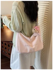 Pink slouchy shoulder bag detail, cute bow bear pendant, soft PU leather commuter purse.