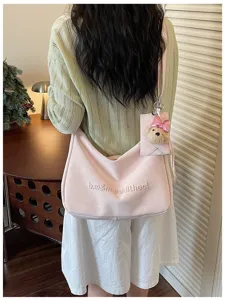 Soft pink hobo shoulder bag for women, casual commuter crossbody purse with cute bear charm.