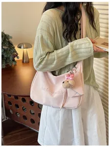 Sweet style pink shoulder bag with cute bear pendant and embroidered text for daily commuting.