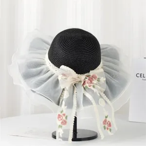 Vista ravvicinata di un cappello da sole nero da donna con tesa larga e fiocco in pizzo.