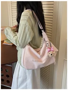 Soft pink slouchy hobo shoulder bag detail, stylish daily commuter accessory with cute bear charm.