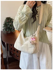 Detail shot of the sweet minimalist crossbody bag with cute bear pendant for daily commuting style.