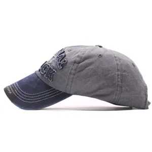 Vue rapprochée de la casquette de baseball en denim délavé montrant les lettres brodées.