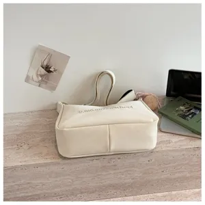 Minimalist cream shoulder bag for women, elegant daily handbag featuring chic embossed lettering.