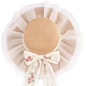 Cappello di paglia da donna con tesa larga in pizzo e fiocco ricamato per vacanze estive.
