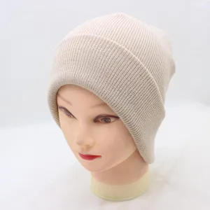 Close-up of ribbed knit texture on the cozy beige winter beanie hat detail view.