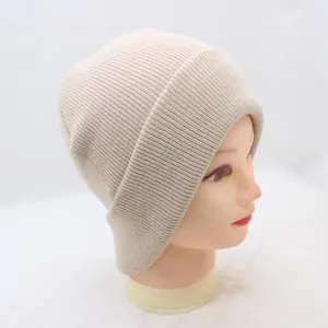 Close-up detail side view of a cozy beige ribbed knit beanie, soft winter warm wool hat.