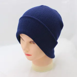 Blue knit beanie winter hat close up showing ribbed texture and folded cuff details.