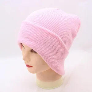 Pink knitted beanie hat detail, soft wool ribbed texture cap for autumn and winter daily wear.