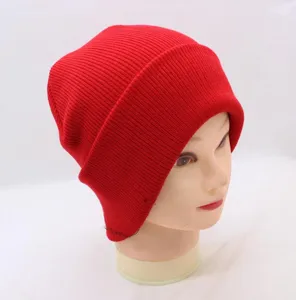 Close-up view of a solid red knitted beanie cap showing fine ribbed texture and stretchy fabric design.