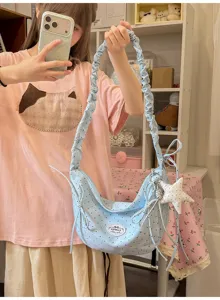 Light blue polka dot crossbody bag with ruffled strap, cute bow and star pendant for sweet girls.