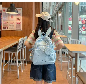 Detailed view of the light blue star print backpack featuring cute charms and front pouch.