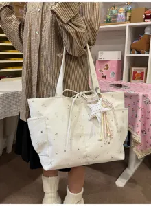 Casual white canvas tote bag for women, featuring celestial star and moon print with cute star charm.