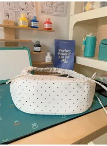 Detailed view of white polka dot crossbody bag featuring cute ruched handle and sweet bow tie.