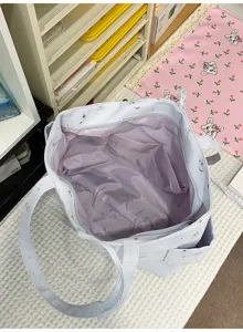 Interior detail of casual tote bag showing purple lining and spacious storage pocket.