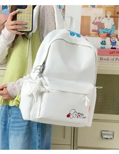 Detailed view of the clean white student backpack featuring a cute flower motif and star pendant.