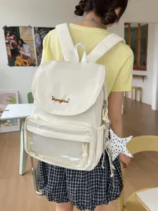 Close-up detail of the sweet beige canvas backpack featuring a clear front pocket and cute charms.