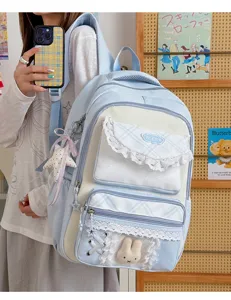 Charmant sac à dos bleu pastel avec dentelle blanche et peluche de lapin pour l'école quotidienne.