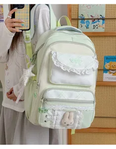 Vue détaillée d'un sac à dos étudiant vert menthe doux avec volants en dentelle et lapin pelucheux.