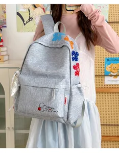 Close-up detail of casual student backpack with colorful embroidered floral patterns and pocket.