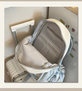 Detailed view of casual white backpack with multiple inner compartments and zip pocket storage.