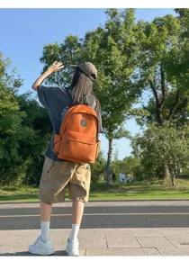 Orange nylon school backpack for women, stylish minimalist daypack for daily casual use.