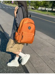 Stylish orange nylon student backpack for daily use, simple design, casual school day bag.