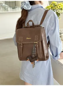 Korean style vintage large capacity PU leather backpack with cute dog charm for daily use.